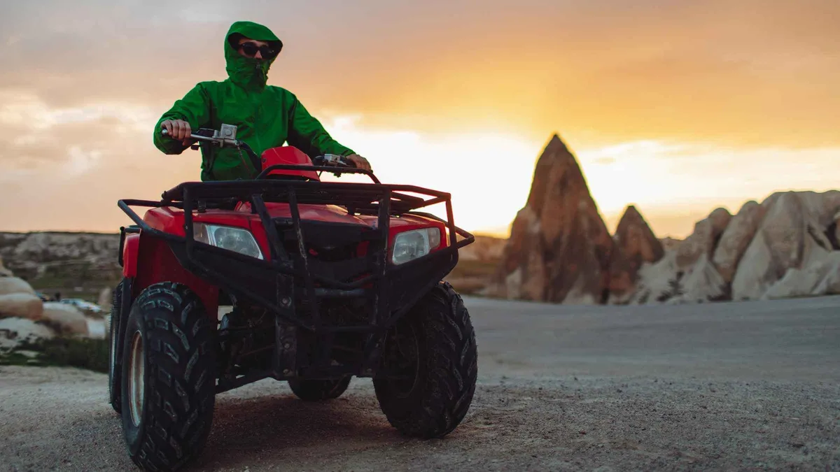 Rider on a quad bike at sunset in the Cappadocia valleys on an ATV tour